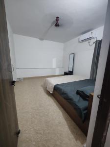 um quarto com uma cama num quarto branco em Independent 2-Room with Kitchen Homestay em Dehradun