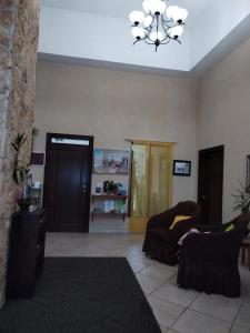 sala de estar con 2 sillas y lámpara de araña en Campestre House en Alto Boquete
