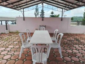 einen weißen Tisch und Stühle auf einer Terrasse in der Unterkunft Burgitos Homescape Tagaytay in Tagaytay