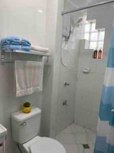 ein weißes Bad mit einer Dusche und einem WC in der Unterkunft Burgitos Homescape Tagaytay in Tagaytay