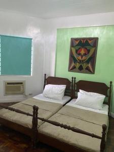 ein Schlafzimmer mit 2 Betten und einem Wandgemälde in der Unterkunft Burgitos Homescape Tagaytay in Tagaytay