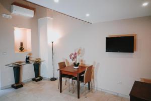 a dining room with a table and a television on a wall at Civico 9 in Brindisi