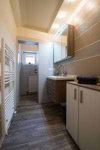 ein Bad mit einem Waschbecken und einem Spiegel in der Unterkunft Ferienwohnung Lechner in Abtenau