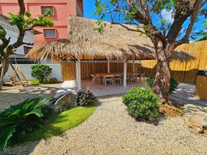 a hut with a table and a straw roof at White house 36 Hatyai in Hat Yai