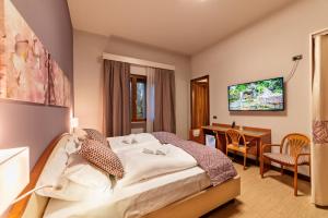 una camera con letto, scrivania e TV di Hotel all'Orso a Biancade