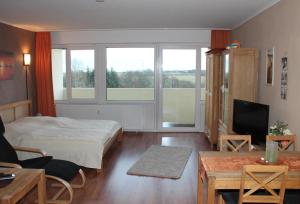 een slaapkamer met een bed en een woonkamer met een tv bij Ferienappartement E612 für 2 Personen an der Ostsee in Brasilien