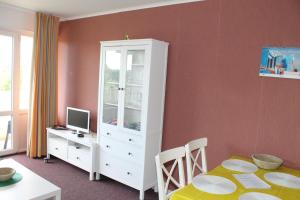 a room with a white cabinet and a desk with a computer at Ferienwohnung E511 für 2-4 Personen an der Ostsee in Brasilien