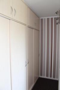 um armário com armários brancos e uma parede listrada em Ferienwohnung E511 für 2-4 Personen an der Ostsee em Brasilien