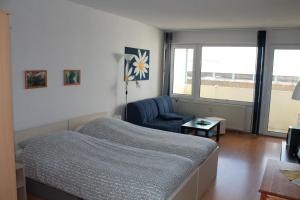 ブラズィリアンにあるFerienappartement K110 für 2-4 Personen in Strandnäheのベッドルーム1室(ベッド1台、椅子、窓付)
