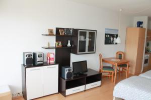 ブラズィリアンにあるFerienappartement K110 für 2-4 Personen in Strandnäheのベッド、デスク、テレビが備わる客室です。