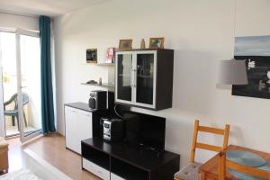 ein Wohnzimmer mit einem TV an der Wand in der Unterkunft Ferienappartement K110 für 2-4 Personen in Strandnähe in Brasilien