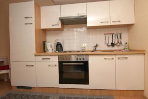 a kitchen with white cabinets and a black oven at Ferienwohnung K013 für 2-4 Personen an der Ostsee in Brasilien