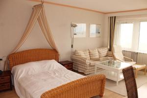 ein Schlafzimmer mit einem Bett und einem Sofa in der Unterkunft Ferienapartment K1003 mit Ostseeblick in Brasilien