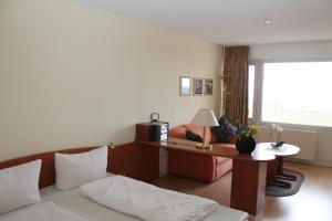 um quarto com uma cama, uma secretária e uma janela em Ferienappartement K1208 mit Ostseeblick em Brasilien