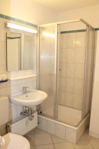 uma casa de banho com um lavatório e um chuveiro em Ferienappartement K1208 mit Ostseeblick em Brasilien