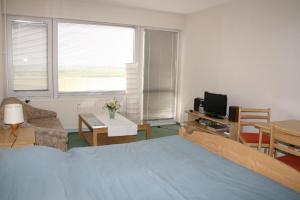 una camera con letto blu e un soggiorno di Ferienappartement K1313 für 2-4 Personen mit Ostseeblick a Schönberg in Holstein