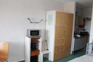 Habitación con cama y microondas en un estante en Ferienwohnung K610 mit Meerblick, en Brasilien