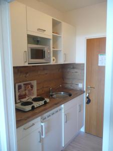 a kitchen with a sink and a microwave at Ferienwohnung K1409 für 2-4 Personen mit Ostseeblick in Brasilien