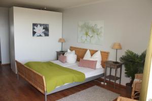 a bedroom with a bed with a green blanket on it at Ferienwohnung K1606 für 2-4 Personen mit Ostseeblick in Kalifornien