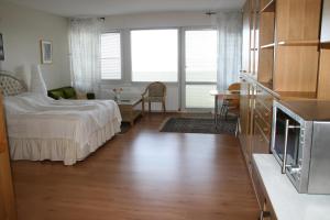 ブラズィリアンにあるFerienappartement K1318 für 2-3 Personen mit Ostseeblickのベッドルーム1室(ベッド1台付)、リビングルームが備わります。