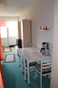 Schönberg in HolsteinにあるFerienappartement K512 für 2-4 Personen in Strandnäheのテーブルと椅子、冷蔵庫が備わる客室です。