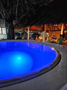 a blue swimming pool in front of a restaurant at White house 36 Hatyai in Hat Yai