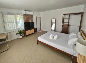 a hotel room with a bed and a television at White house 36 Hatyai in Hat Yai