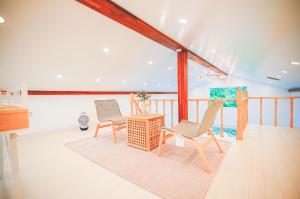 uma sala de estar com duas cadeiras e uma mesa em Jeju Love Stay Mint em Jeju