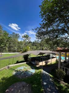 a house with a bridge over a pond at Chácara Recanto do Guerreiro em Aruja in Arujá
