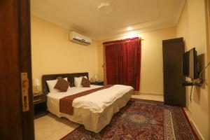 a hotel room with a bed and a television at العيرى للشقق المخدومه جازان 1 in Jazan