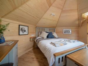 a bedroom with a bed in a wooden cabin at Dol Y Mynydd the Mountain Meadow-qu7521 in Llangerniew