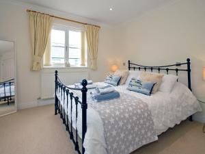 a bedroom with a black and white bed with blue pillows at Havens Rest in Walton West
