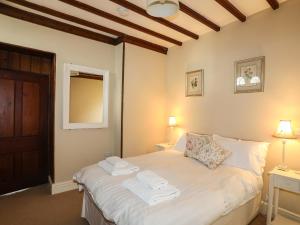 a bedroom with a bed with towels on it at Cabbage Patch in Rhoscolyn