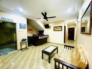 a living room with a couch and a ceiling fan at DAILY INN HOTEL in Mersing
