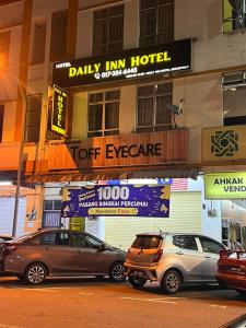 um grupo de carros estacionados em frente a um hotel em DAILY INN HOTEL em Mersing