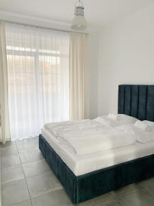 a large bed in a room with a window at BB Residence in Arad