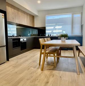 een keuken met een tafel en stoelen in een kamer bij Vinrace City Escape in Adelaide