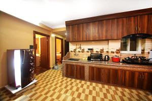 a large kitchen with wooden cabinets and a refrigerator at The Address Apartment Kathmandu in Kathmandu