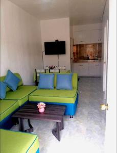 a living room with a green couch and a table at My Lovely Apartment in Dipolog
