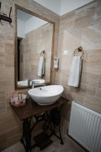 ein Badezimmer mit einem weißen Waschbecken und einem Spiegel in der Unterkunft Petershaus - casa de vacanța și distractie. 