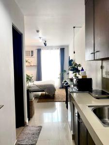 a kitchen with a sink and a living room at Buenbyahe Rooms Studio Type Mandaluyong Edsa Shaw MRT Studio at F Residences Under new management in Manila