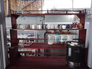 een keuken met een plank met potten en pannen bij City Backpackers in Luang Prabang