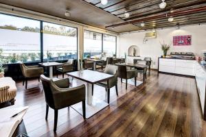 - un restaurant avec des tables, des chaises et de grandes fenêtres dans l'établissement Hotel Hofmann, à Salzbourg