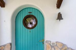 una puerta verde en un edificio con campana en Italian Coastal Charm: Villa in San Felice Circeo en San Felice Circeo