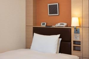 高崎的住宿－高崎大都會酒店，酒店客房配有一张床和电话