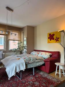 a bedroom with a bed and a red couch at Traum-Stadt-Wohnung in Augsburg