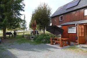 un banco con sombrilla junto a un edificio en Alpenranch, 