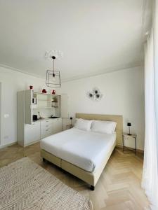 a white bedroom with a large white bed and a rug at Casa Rafanelli in Monforte dʼAlba