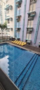 a large swimming pool in front of a building at F&M Relaxing Hotel in Manila