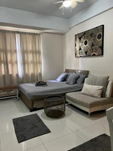 a bedroom with a bed and a couch and a chair at F&M Relaxing Hotel in Manila